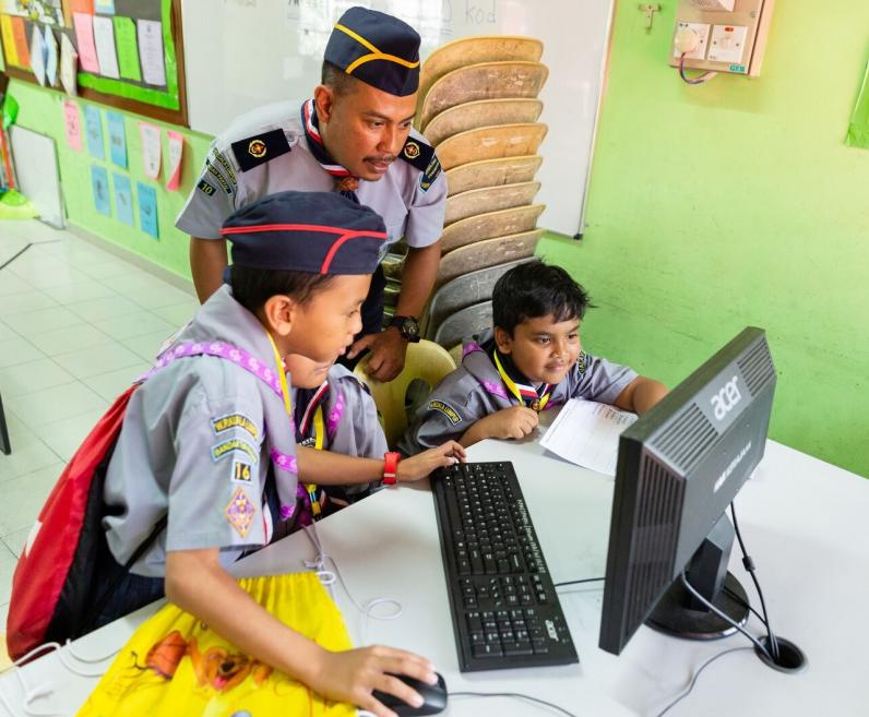 photo: Scouts at keyboard being supported by adult