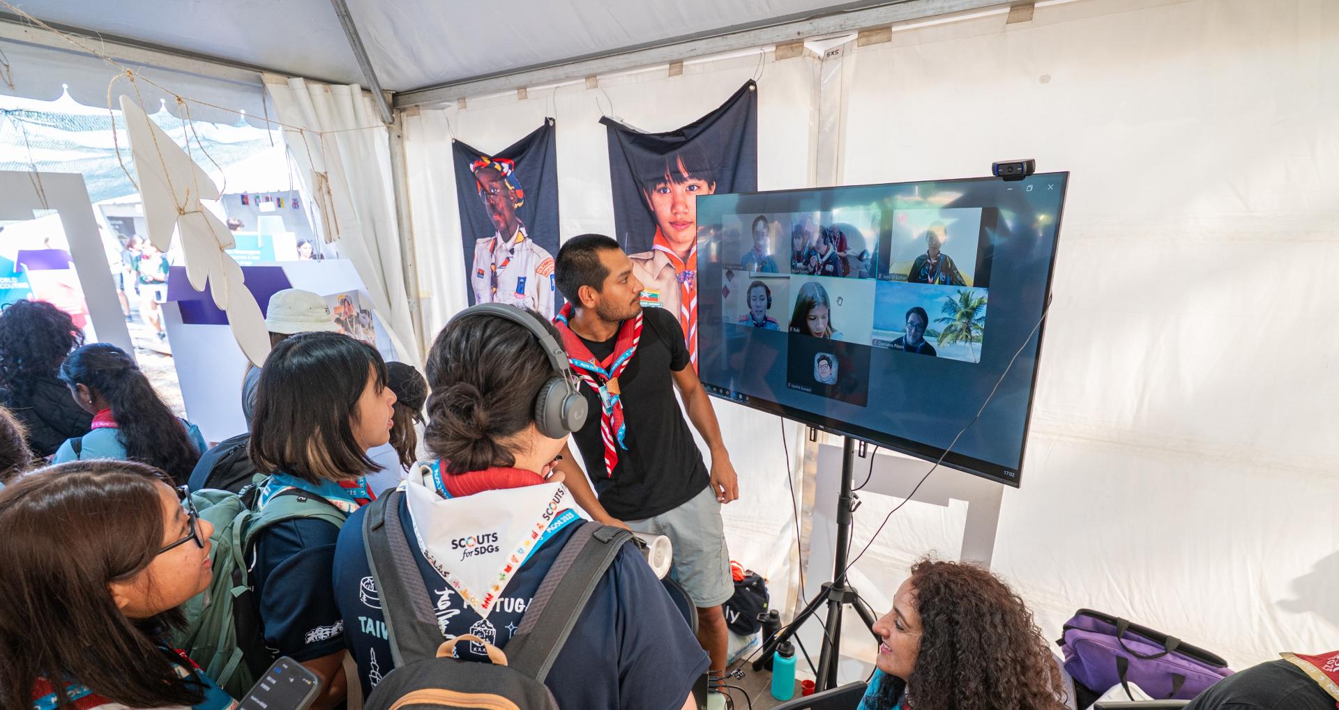 Scouts participating in a video call at the JOTA-JOTI booth during the World Scout Moot.